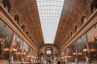 a group of people standing in a room with paintings on the walls