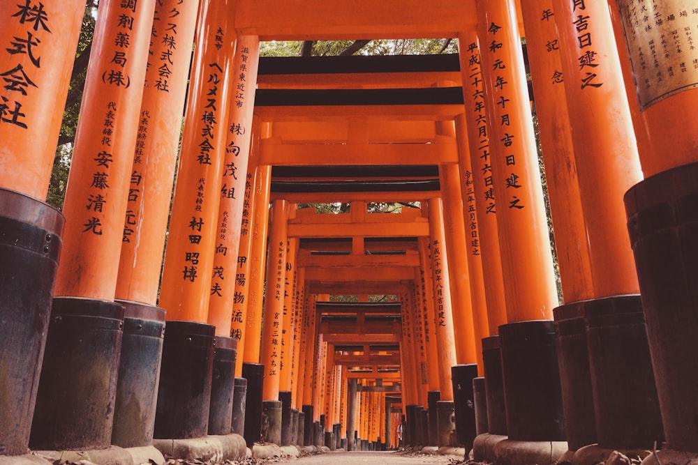 a row of orange and black pillars with writing on them