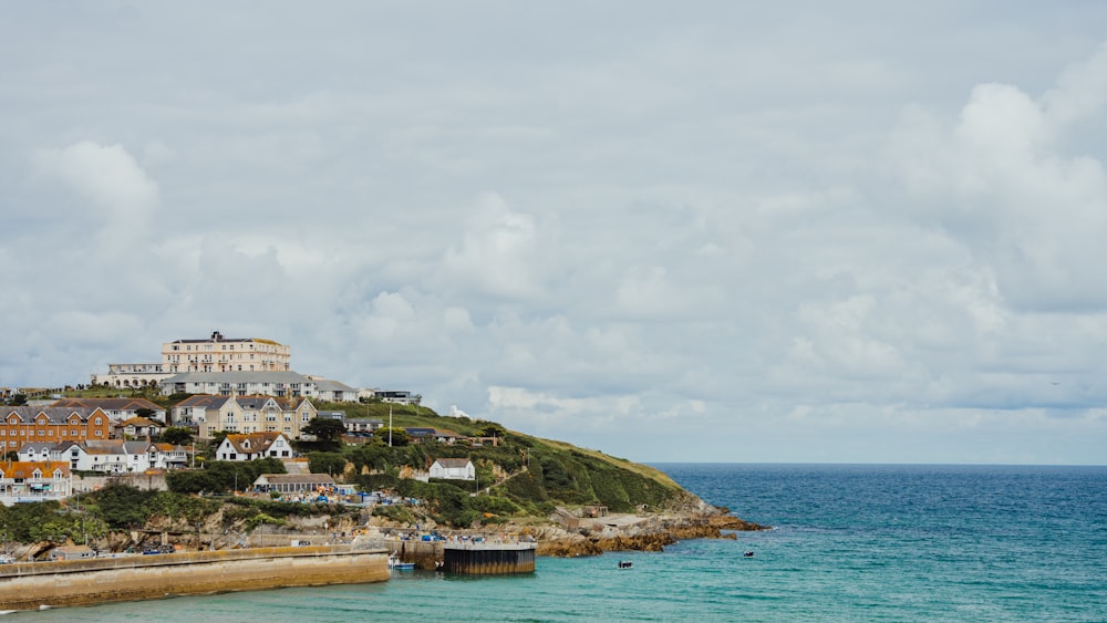 a view of a beach with houses on a hill in the background