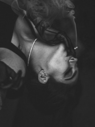 Black and white photograph of an elegant woman meditating with subtle golden light accents.