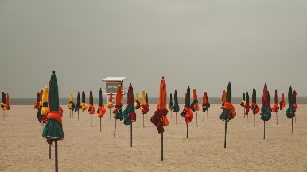 ein Haufen Regenschirme, die im Sand liegen