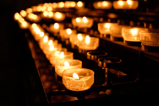 A vibrant array of candles lit softly, their gentle flickers dancing against the cozy backdrop of hand-crafted ceramics.