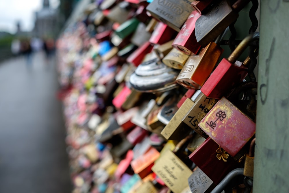 a wall covered with lots of padlocks and locks