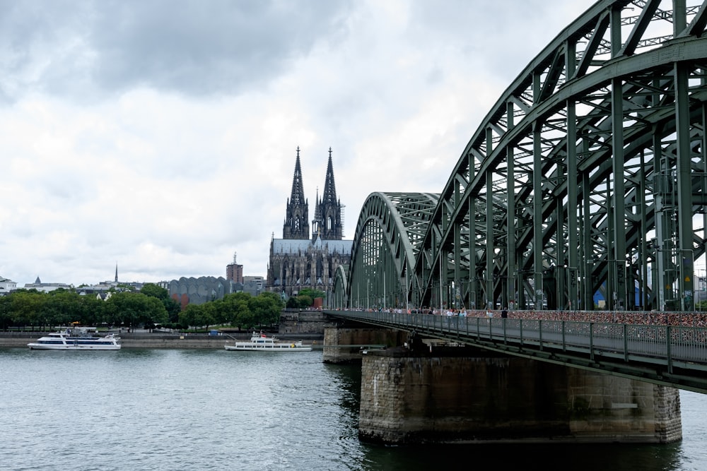 a bridge over a body of water with a cathedral in the background