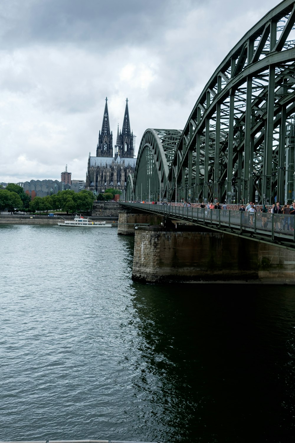 a bridge over a body of water with a cathedral in the background