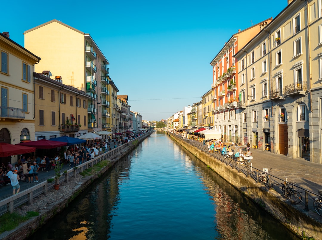 a river running through a city next to tall buildings, 