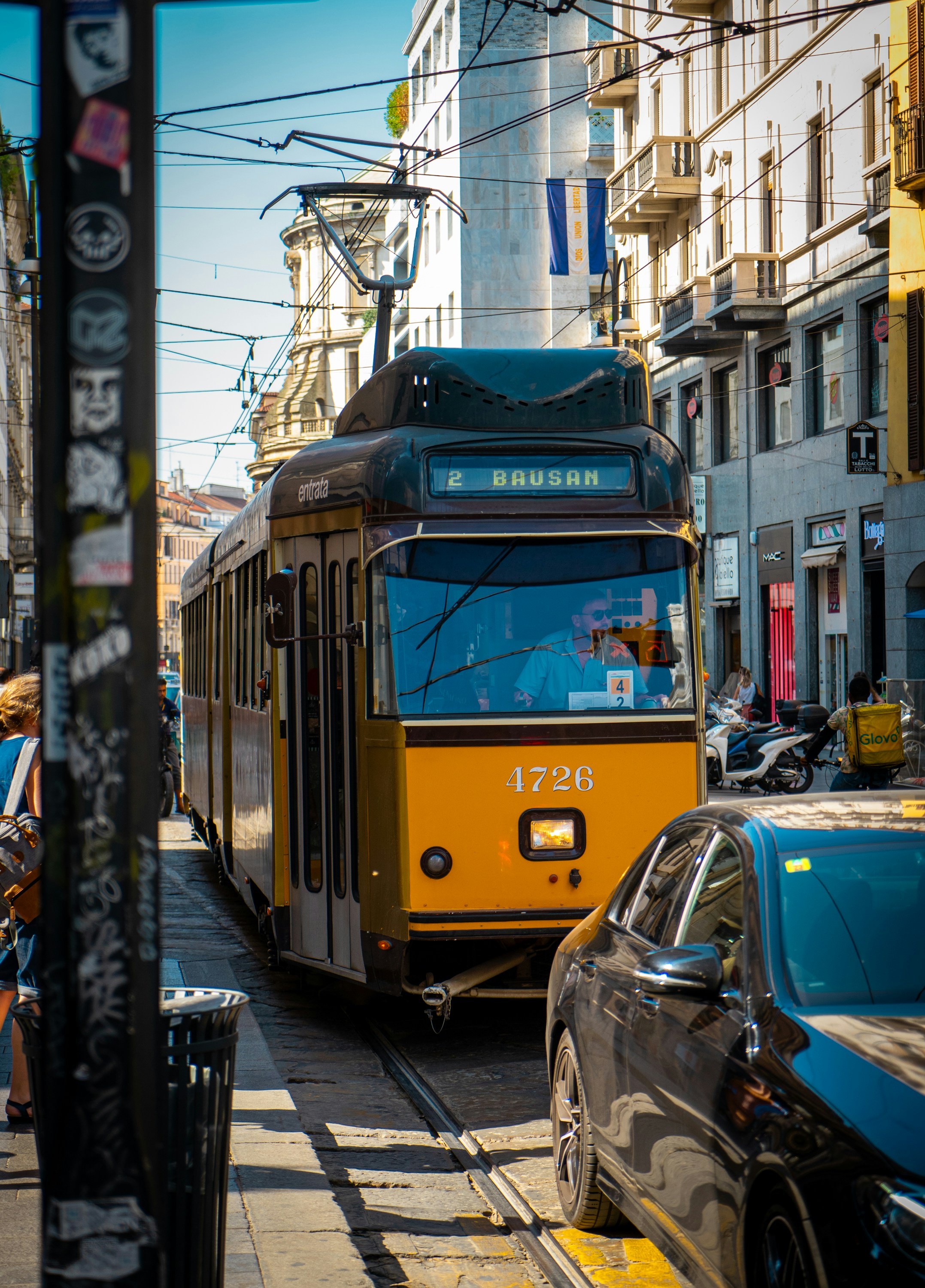 ein-gelb-schwarzer-trolley-auf-einer-stadtstra-e-foto-kostenloses
