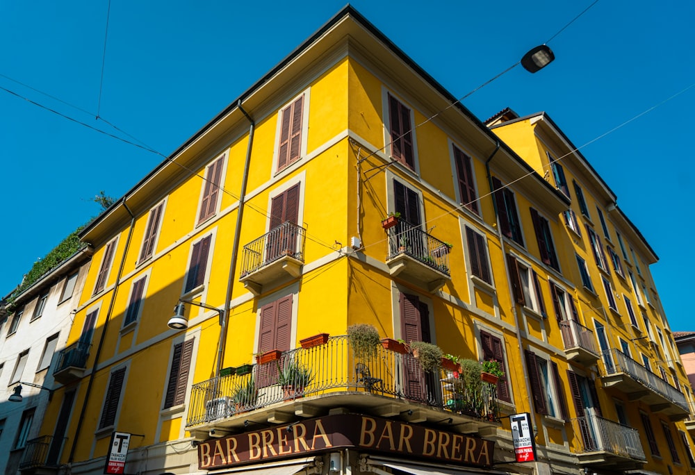 a yellow building with a balcony and balconies