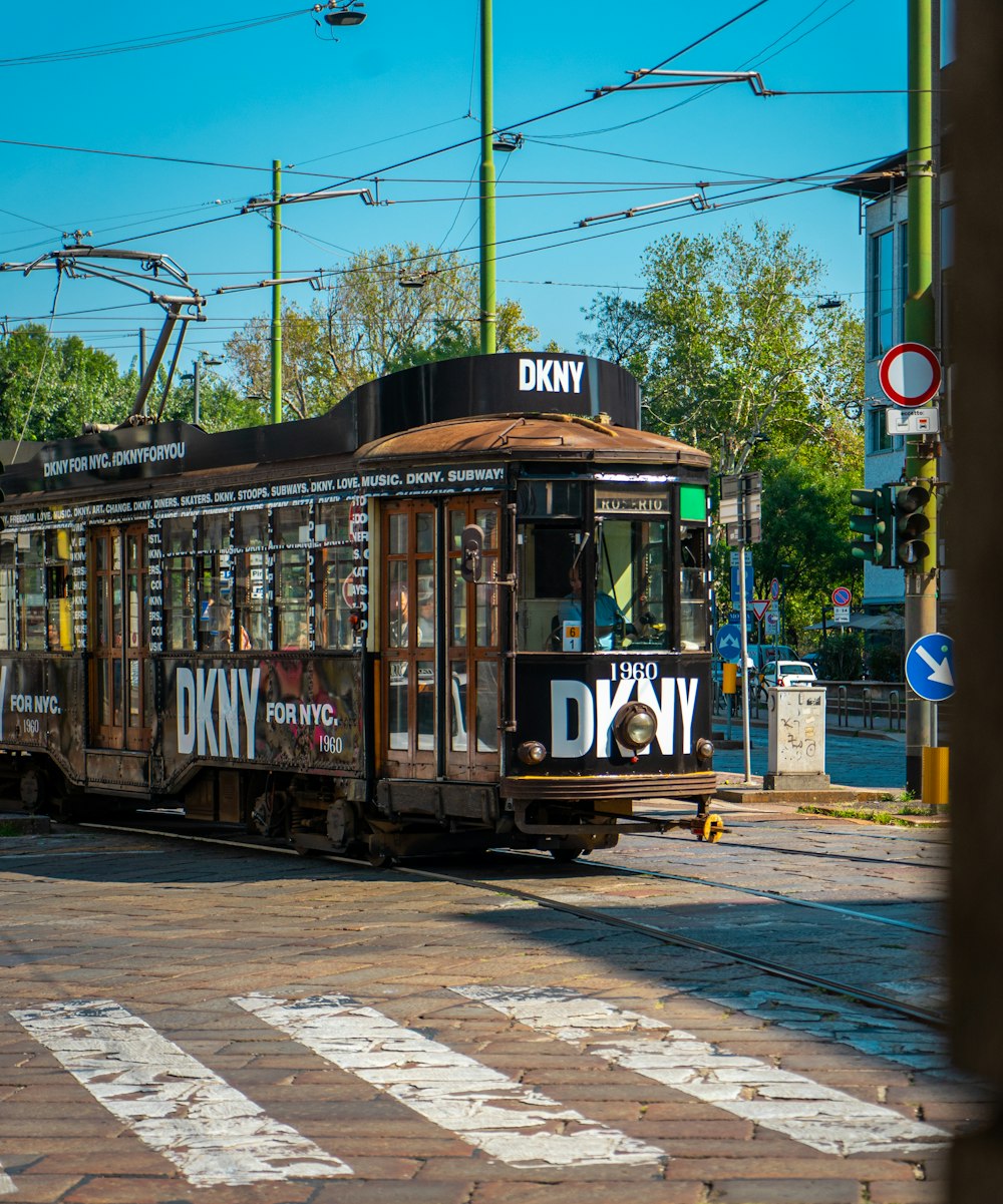 a trolley car on a city street with trees in the background