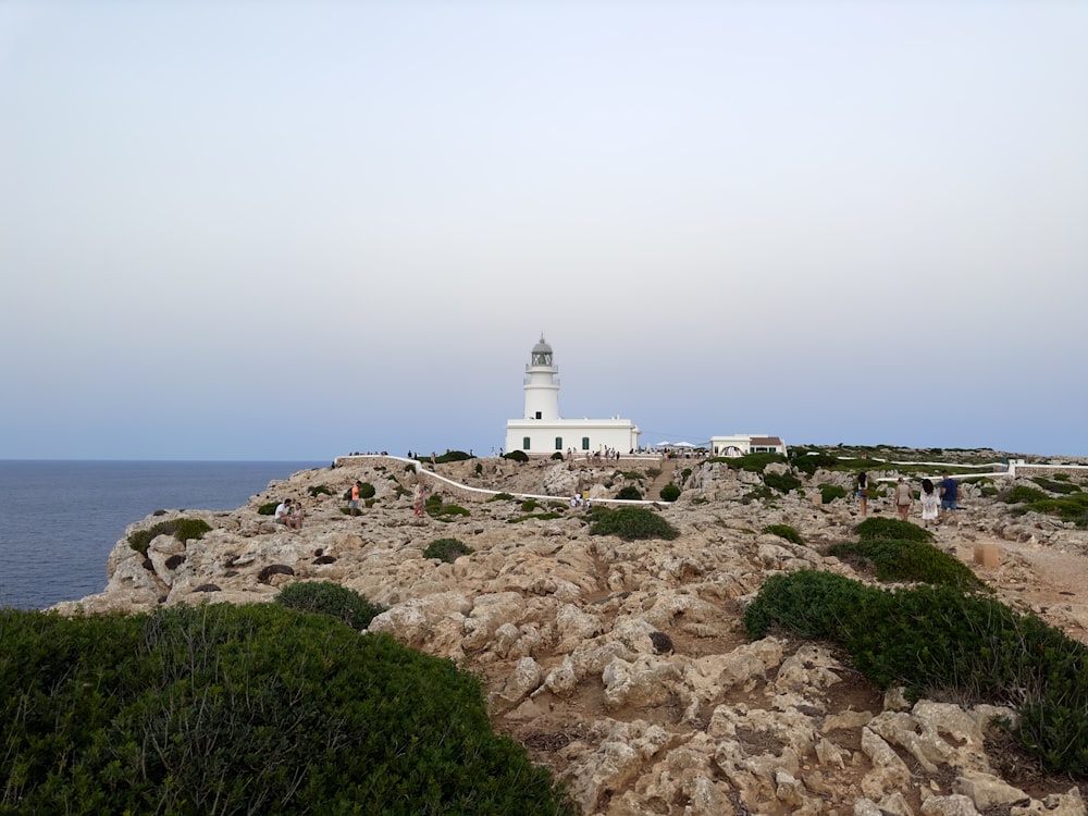 Ein weißer Leuchtturm auf einer felsigen Klippe am Meer