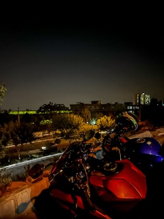 A motorcycle parked near a café, with a city skyline in the background.
