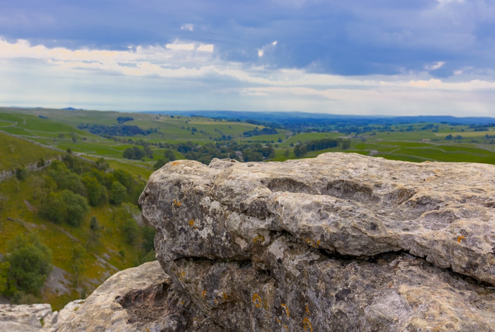 a rock with a view of a valley below