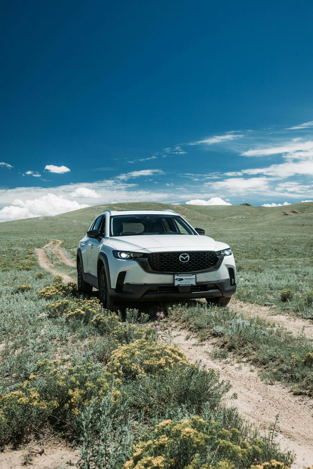 a car is parked on a dirt road