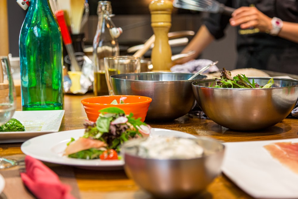 a wooden table topped with bowls of food