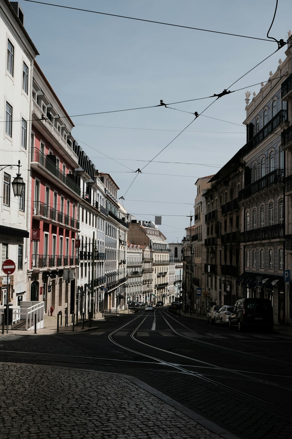 a city street with buildings and wires above it