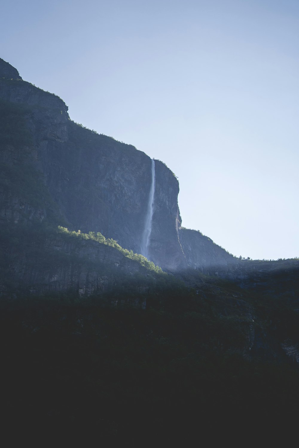 a waterfall is seen from the side of a mountain