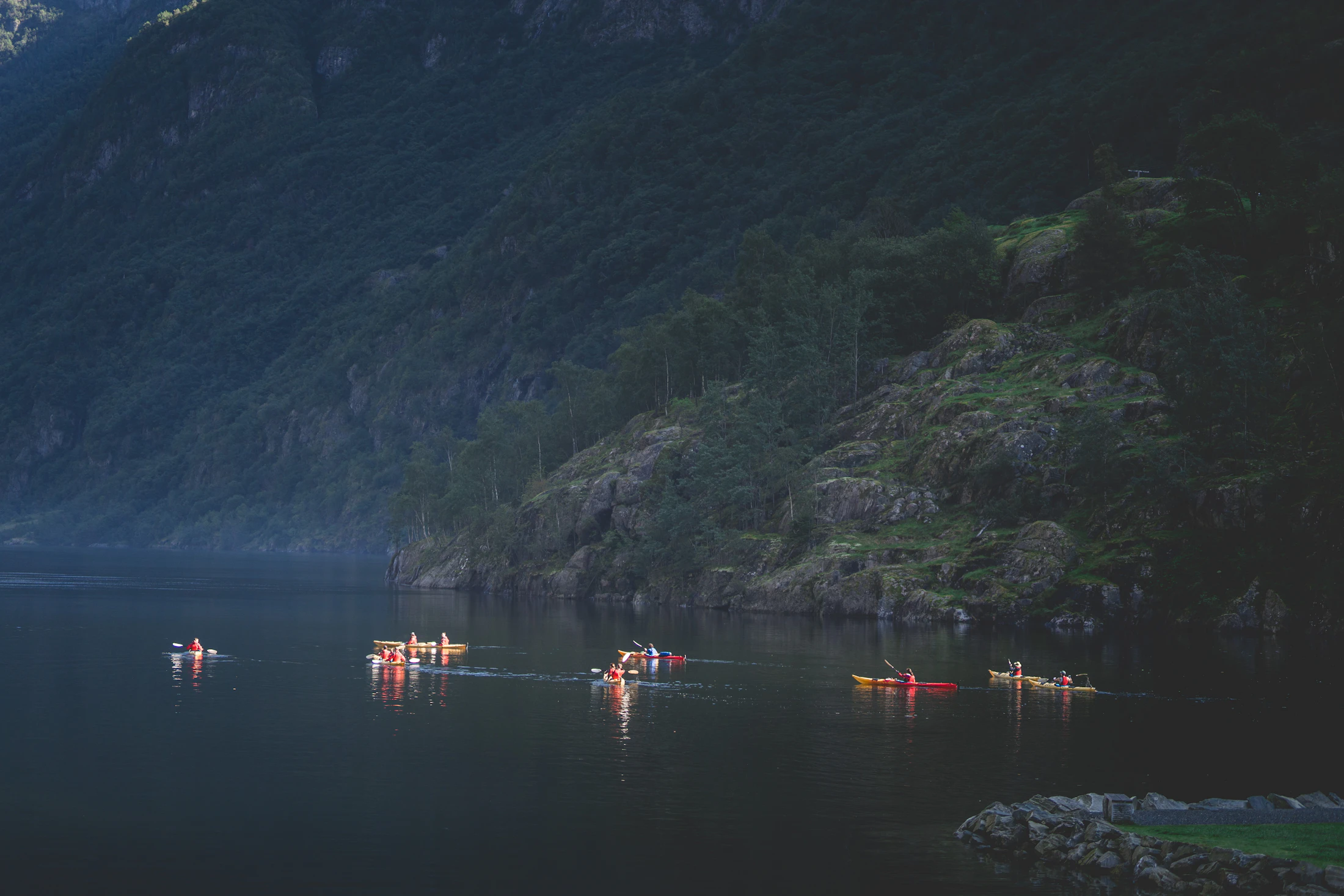 Kayakistes traversant un lac entre les montagnes