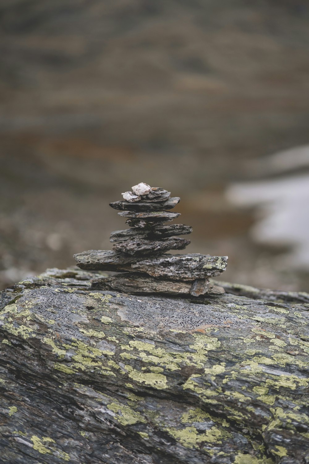 Una pila di rocce sedute sulla cima di una roccia coperta di licheni
