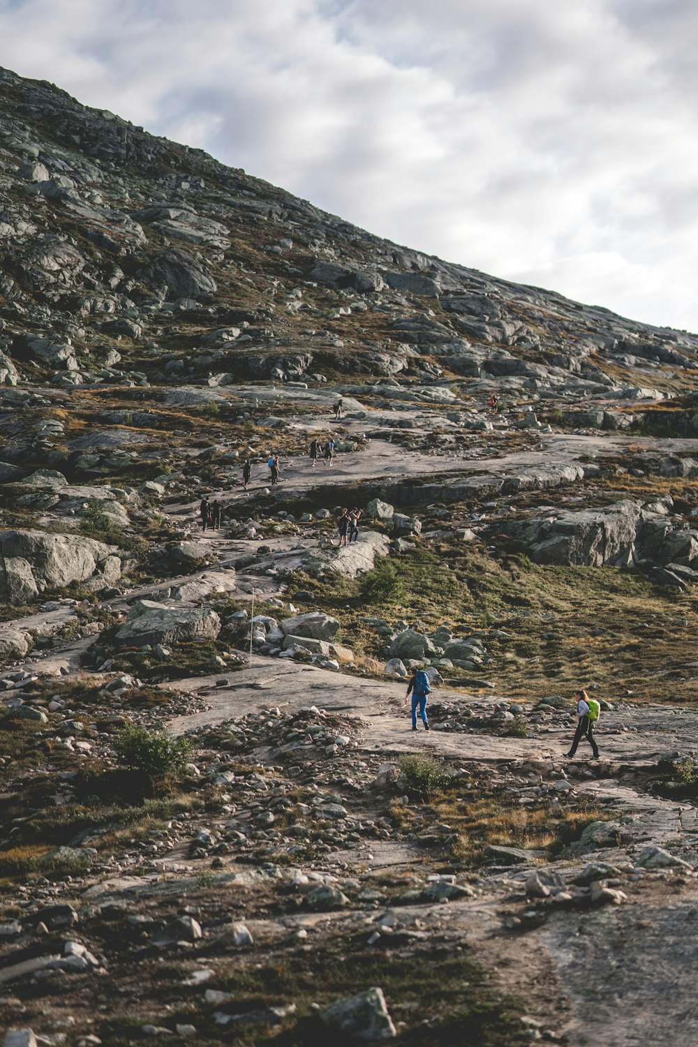 a group of people hiking up a rocky hill