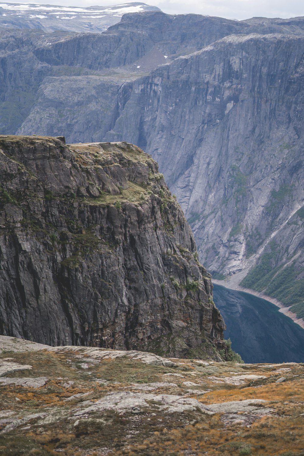 a man standing on top of a mountain next to a valley