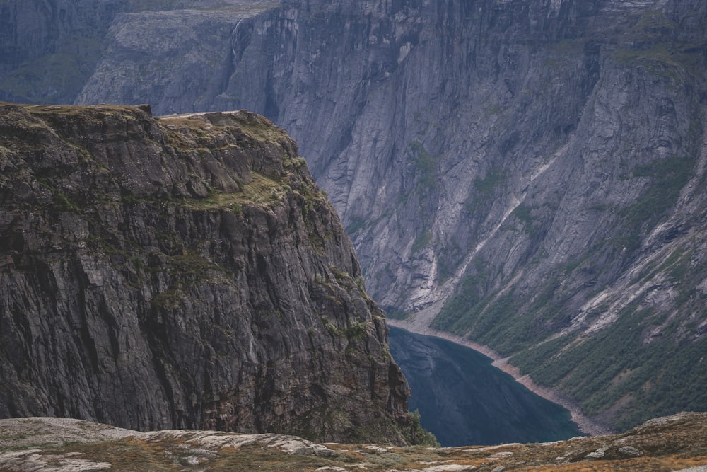 eine Person, die auf einer Klippe mit Blick auf ein Tal steht