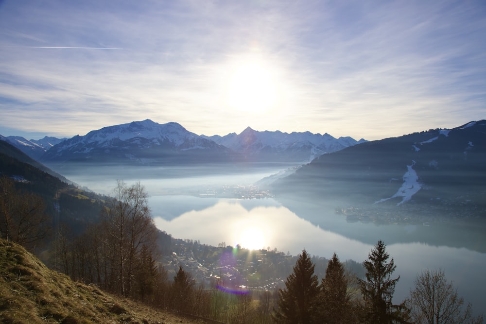 the sun is shining over the mountains and a lake