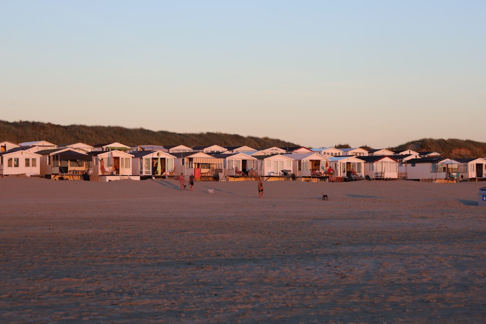 une rangée de maisons assises au sommet d’une plage de sable