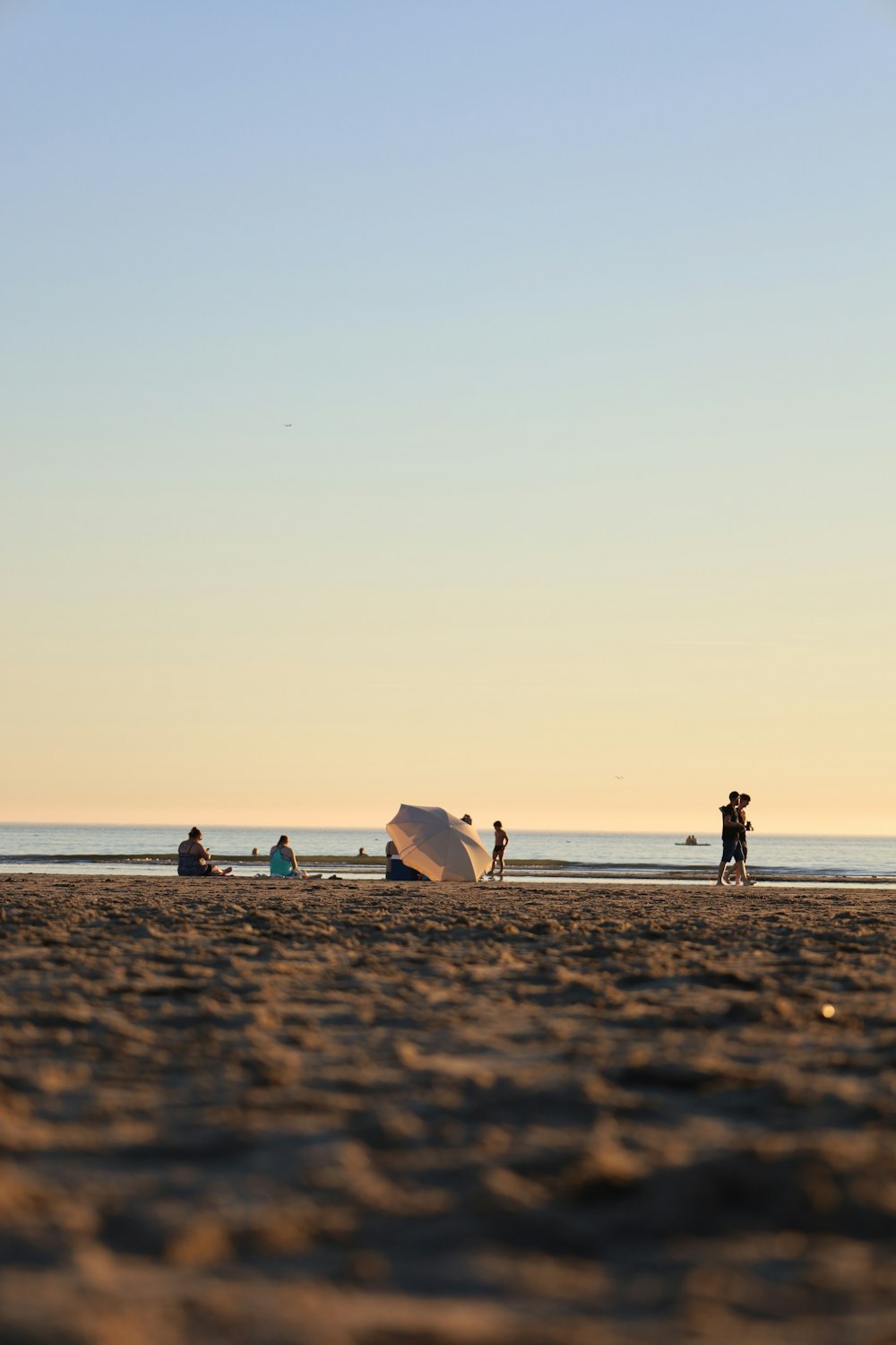 a group of people standing on top of a sandy beach