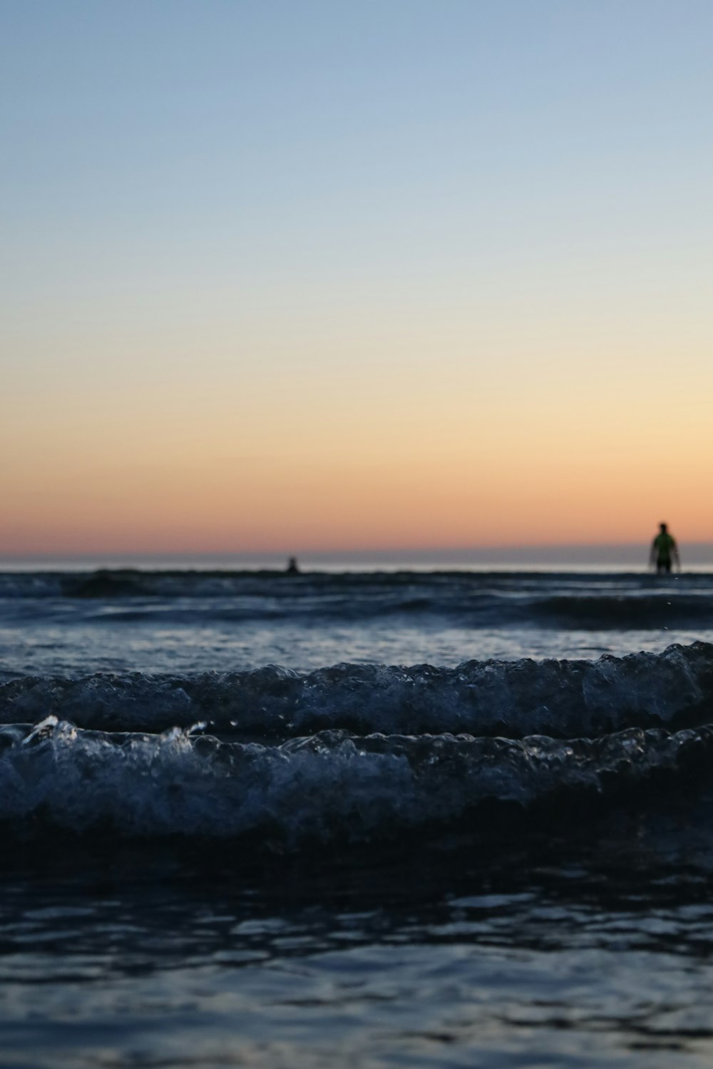 una persona montando una tabla de surf encima de una ola