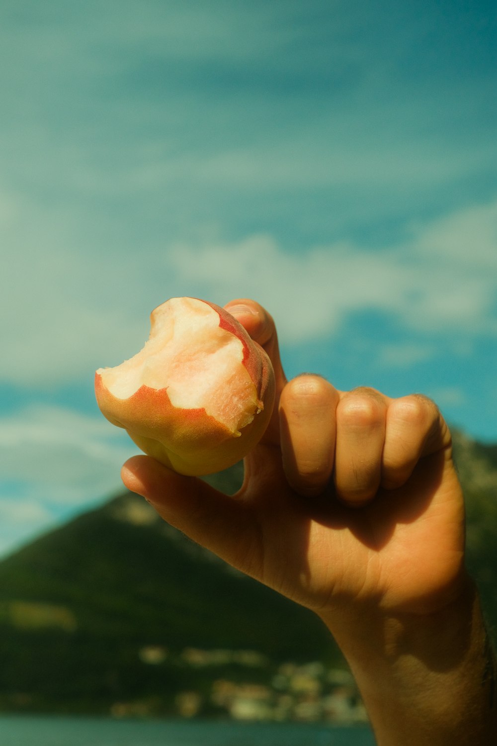 a person holding a piece of fruit in their hand