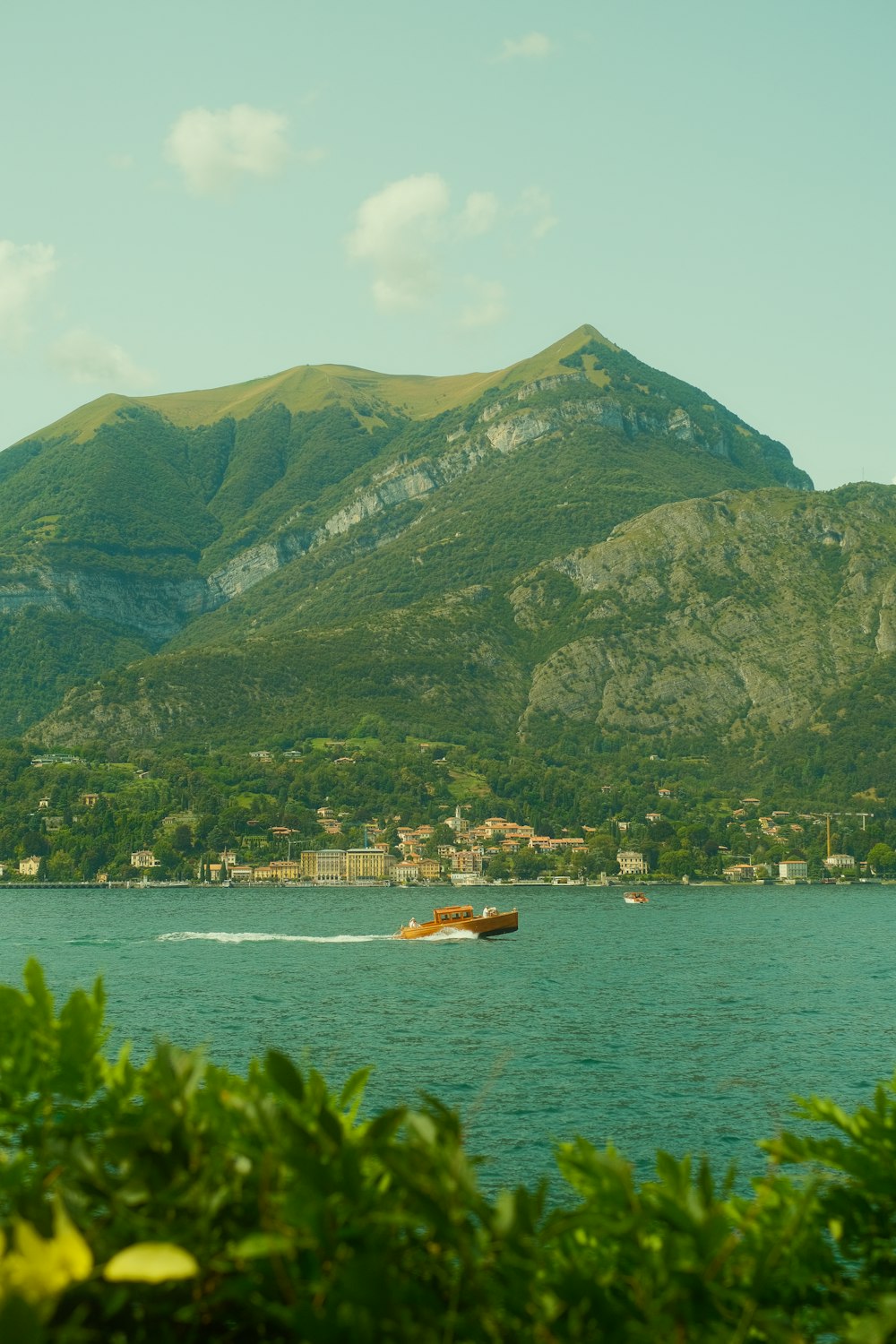 a boat is in the water with a mountain in the background