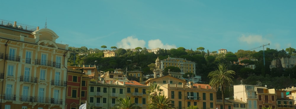 a row of buildings on a hill with a blue sky in the background