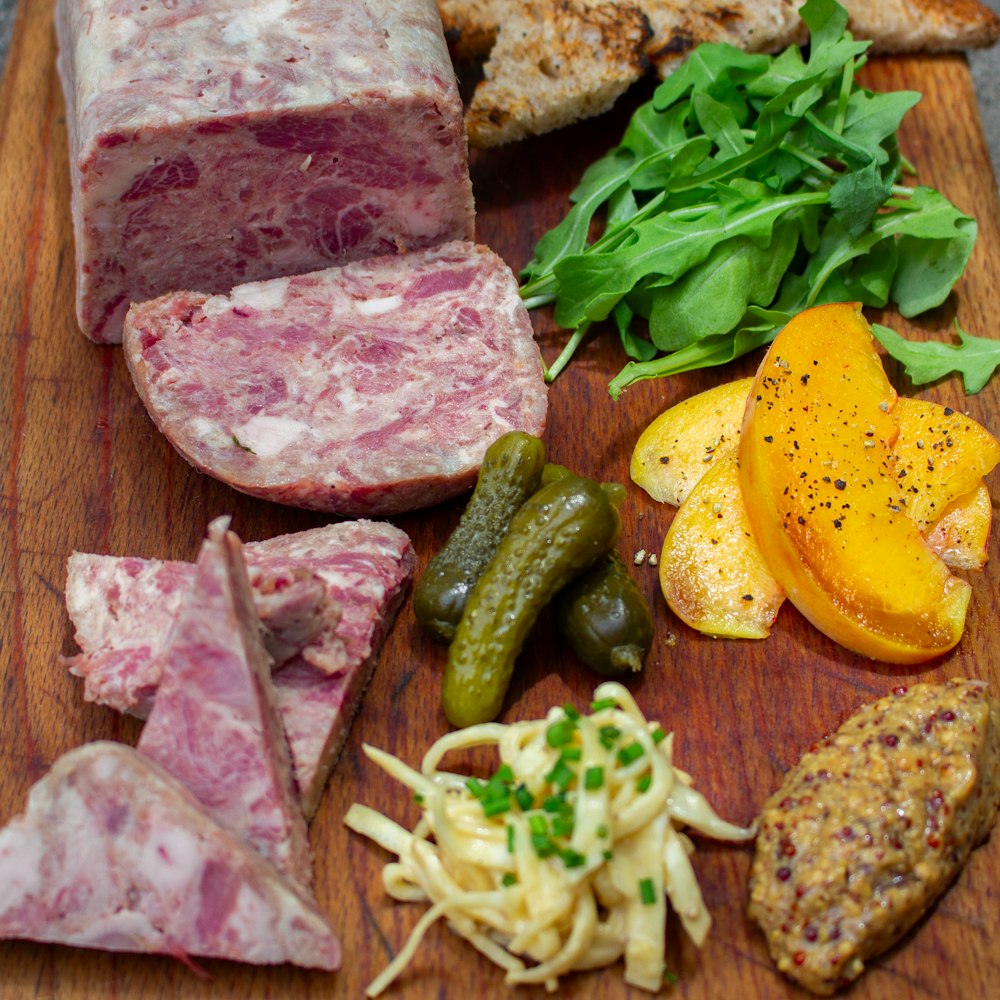 a wooden cutting board topped with meat and veggies