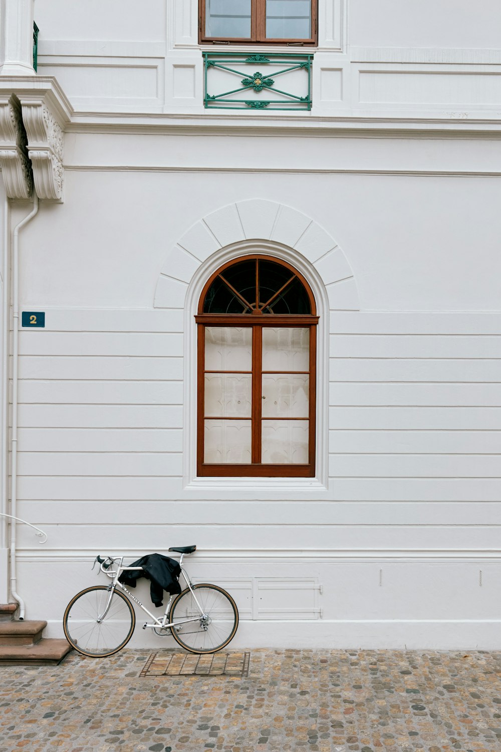 a bicycle parked in front of a white building