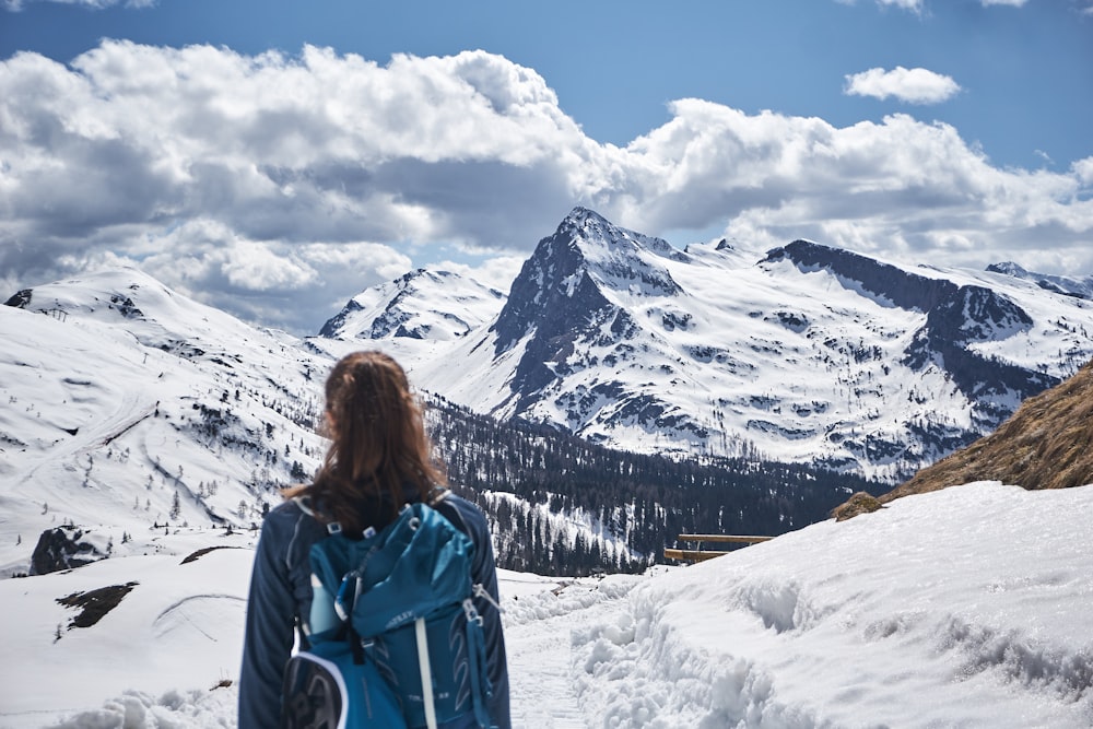 a woman standing on top of a snow covered slope