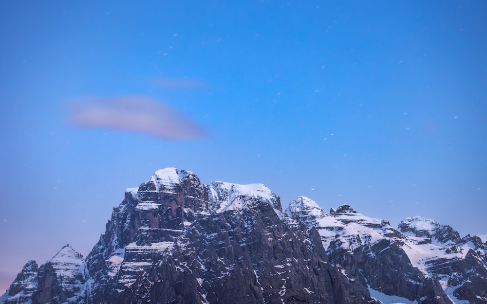 a snow covered mountain with a cloud in the sky