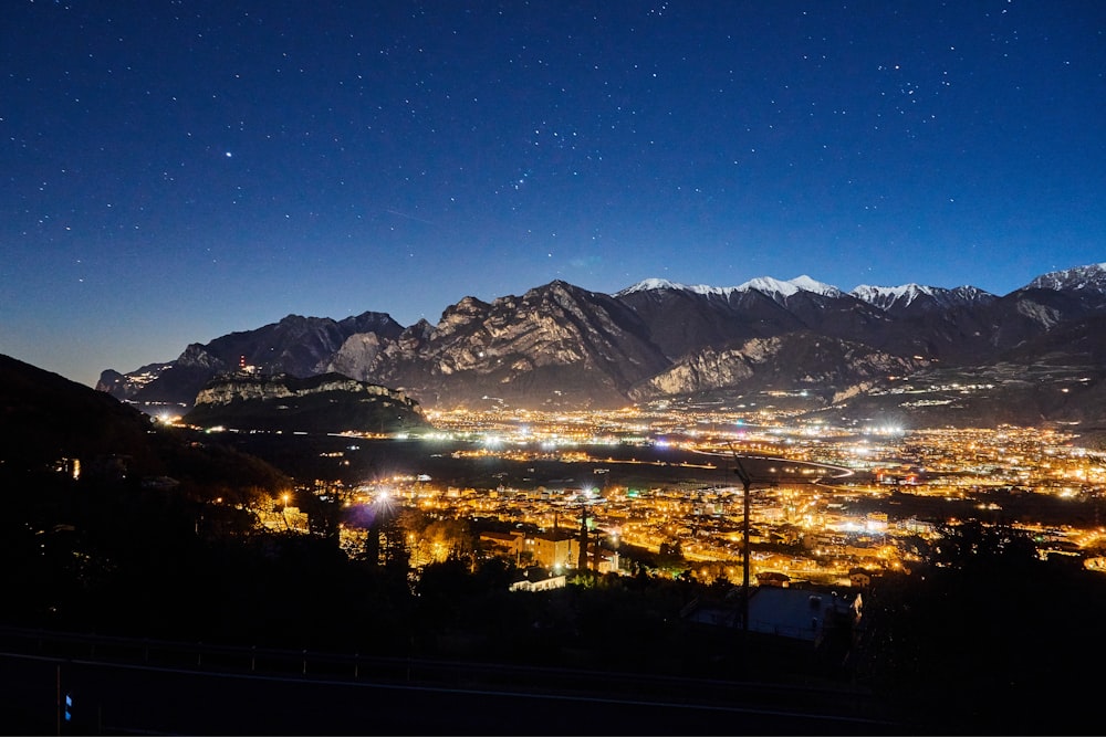 a view of a city at night with mountains in the background