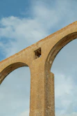 a large stone arch with a sky background