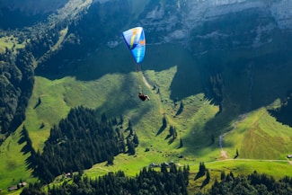 Paraglider gracefully soaring over lush green mountains at sunrise in the Rieti valley