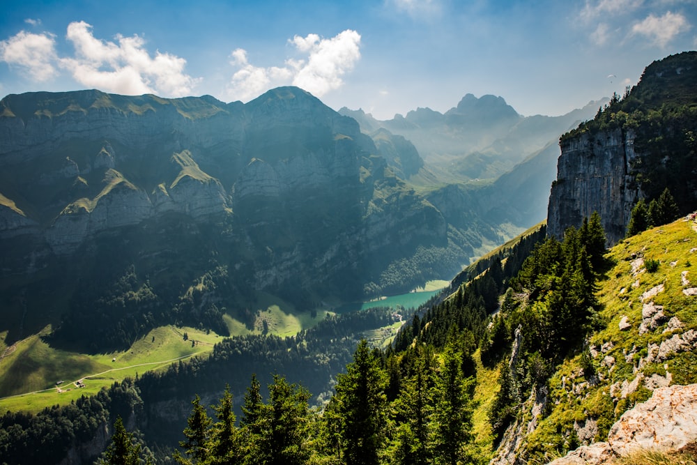 a scenic view of a valley with mountains in the background