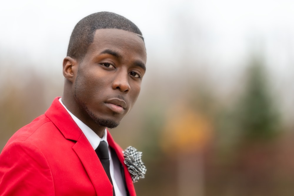 a man in a red jacket and black tie