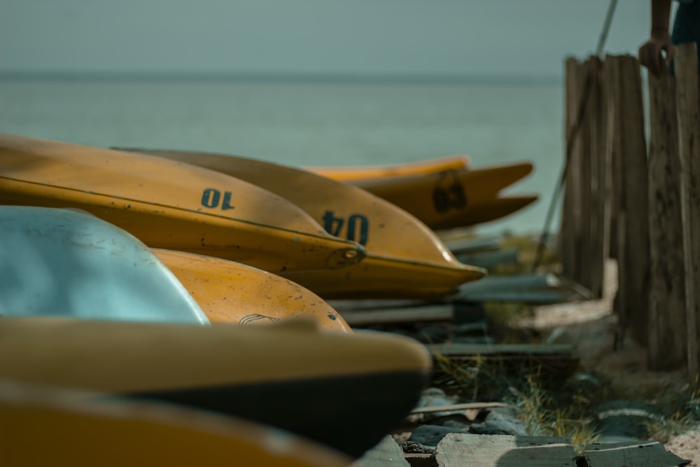 uma fileira de barcos amarelos sentados em cima de uma praia