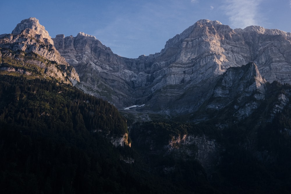 a view of a mountain range with trees and mountains in the background