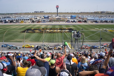 Crowd of enthusiastic fans watching a motorsport event from grandstands.