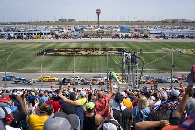 Photo of excited fans cheering at a Formula 1 race track.