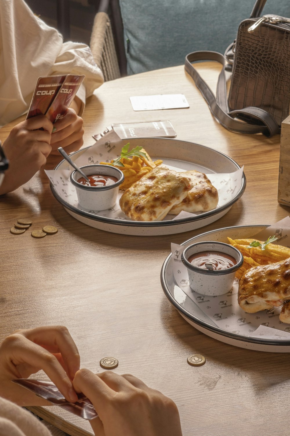 a person sitting at a table with two plates of food