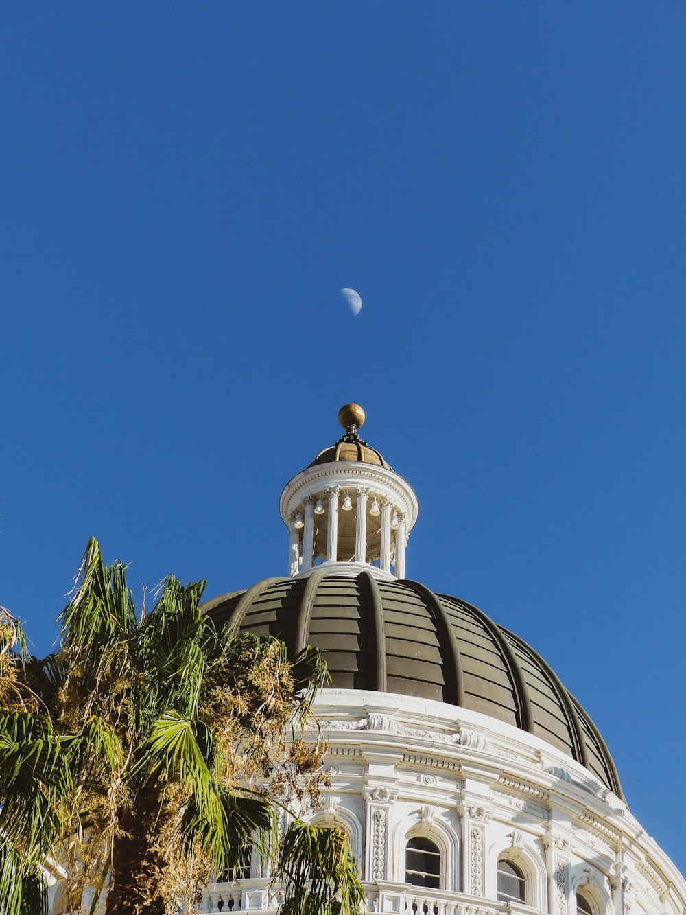 un dôme au sommet d’un bâtiment avec une lune dans le ciel