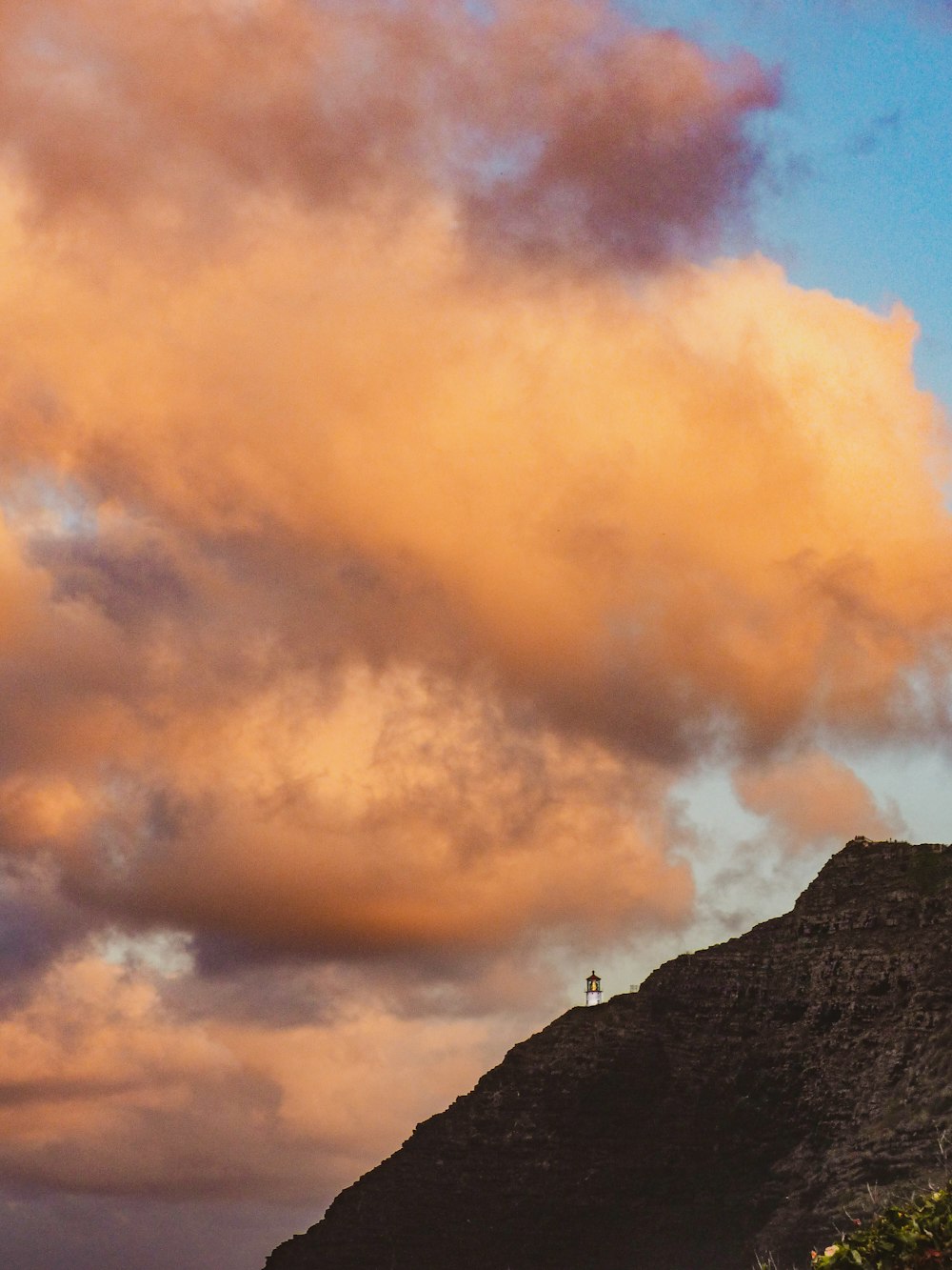 a person standing on top of a mountain under a cloudy sky
