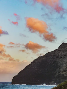 Dramatic view of Cap Spartel lighthouse where the Atlantic Ocean meets the Mediterranean Sea under a bright blue sky.
