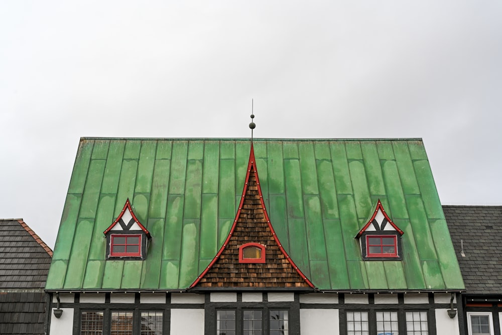 a house with a green roof and two windows